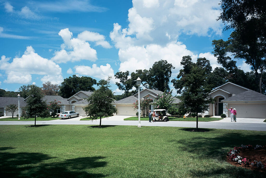 Neighbors waving hello outside of their cottage homes at John Knox Village.
